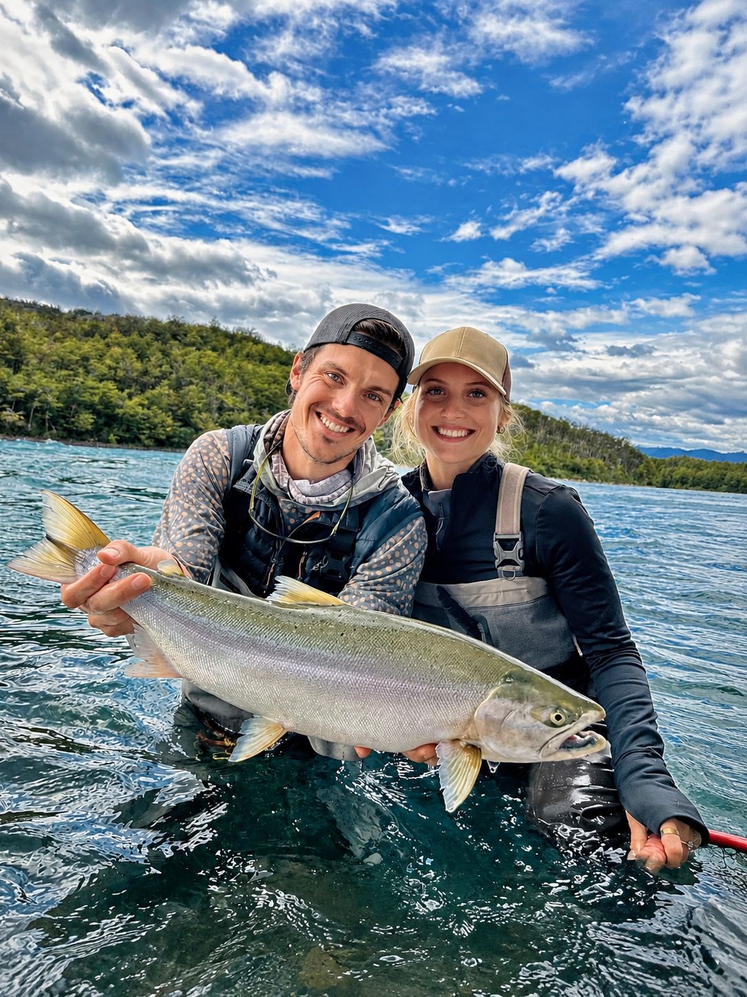Two anglers holding a rainbow trout in a Patagonian lake