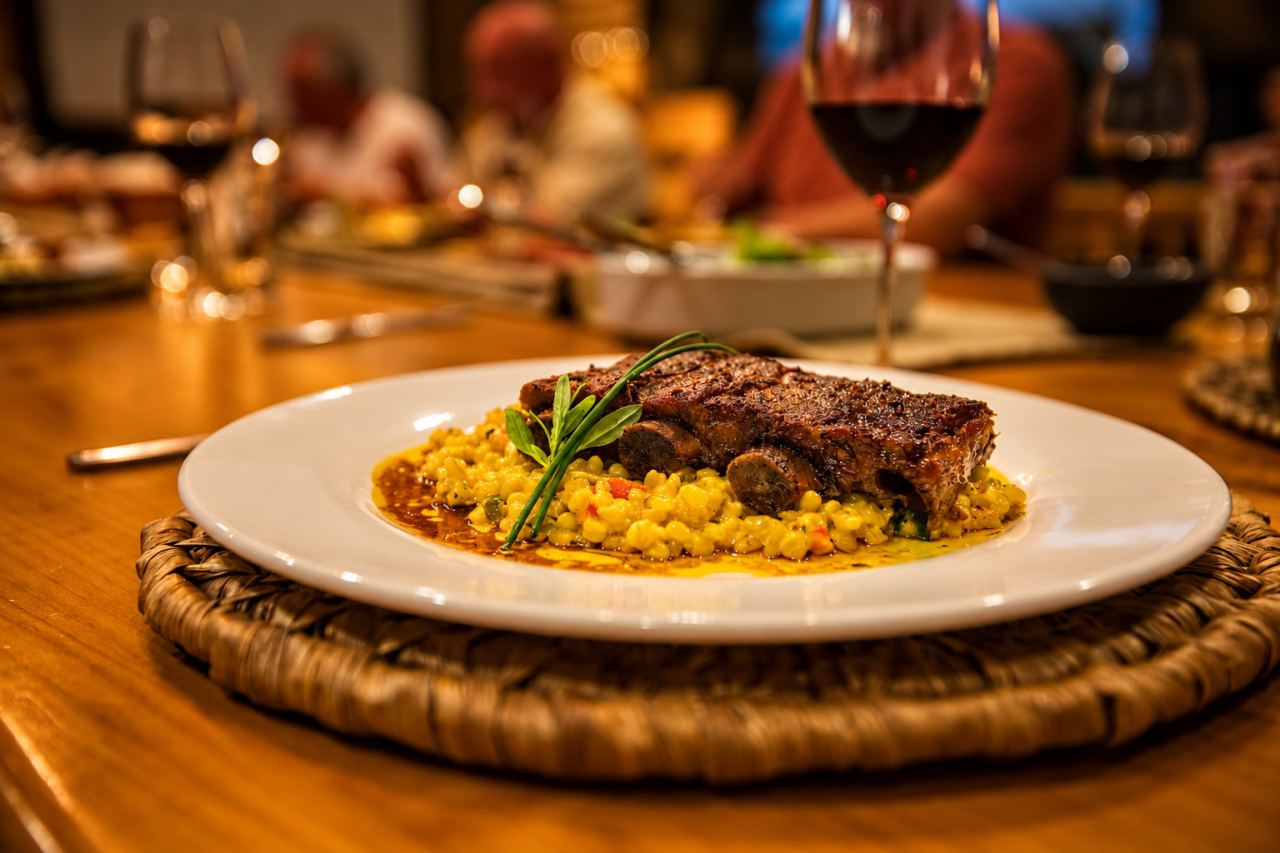A plated main course with rice and a rosemary sprig