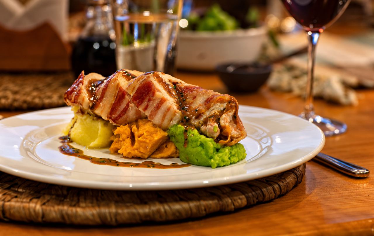 Bacon-wrapped roll with mashed potato and greens