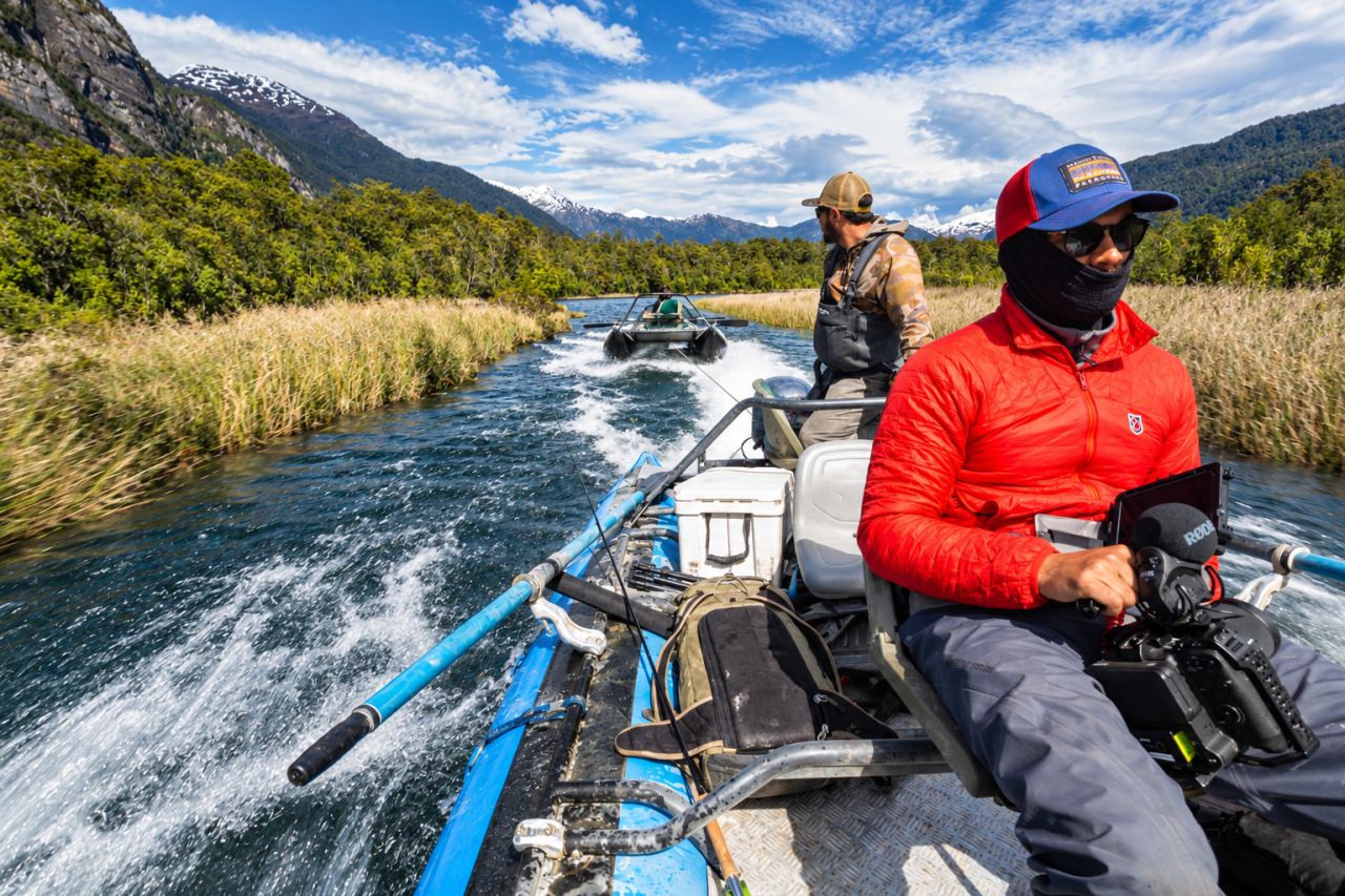 Guide rowing a raft downriver with an angler in the bow