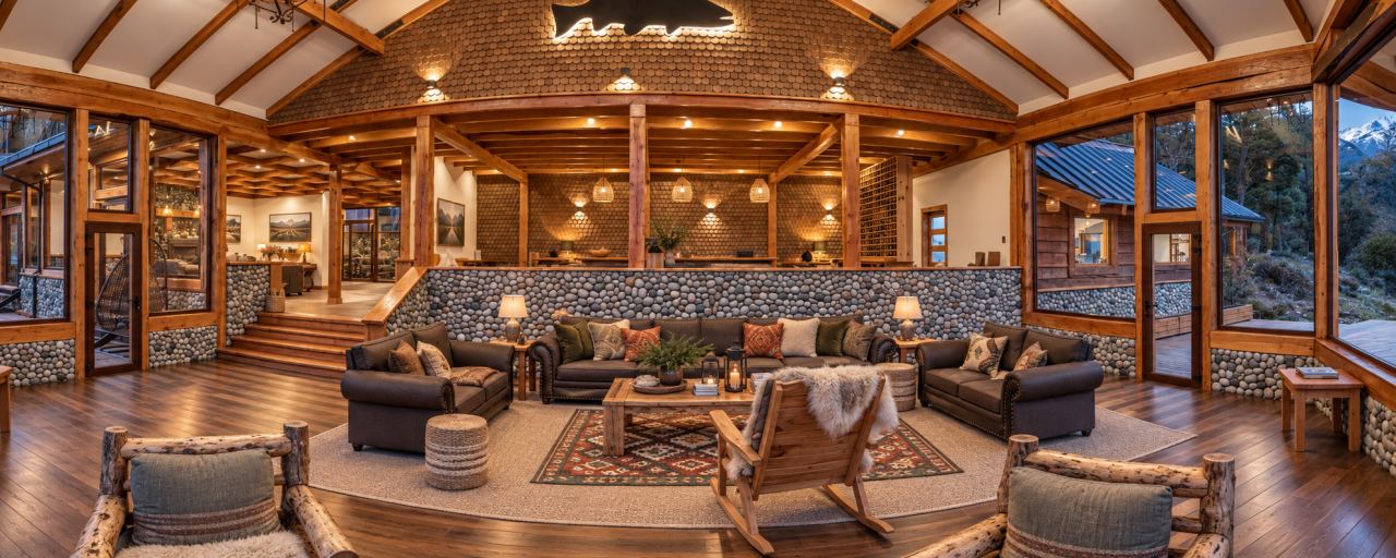 Timber-frame lounge with a stone fireplace at the lodge