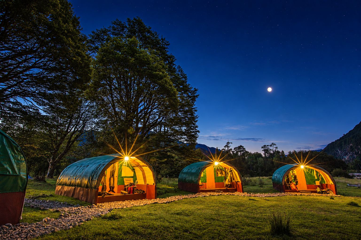 The basecamp tents lit up under a moonlit sky